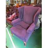 A pair of wing armchairs in aubergine on cabriole legs.