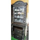 A carved oak bookcase with glazed door, drawer and cupboard