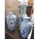 A large blue and white vase decorated flowers and birds and two others decorated flowers