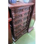 A tall carved oak chest of six drawers with lions head handles