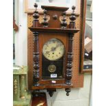 A Victorian walnut wall clock with glass door revealing pendulum