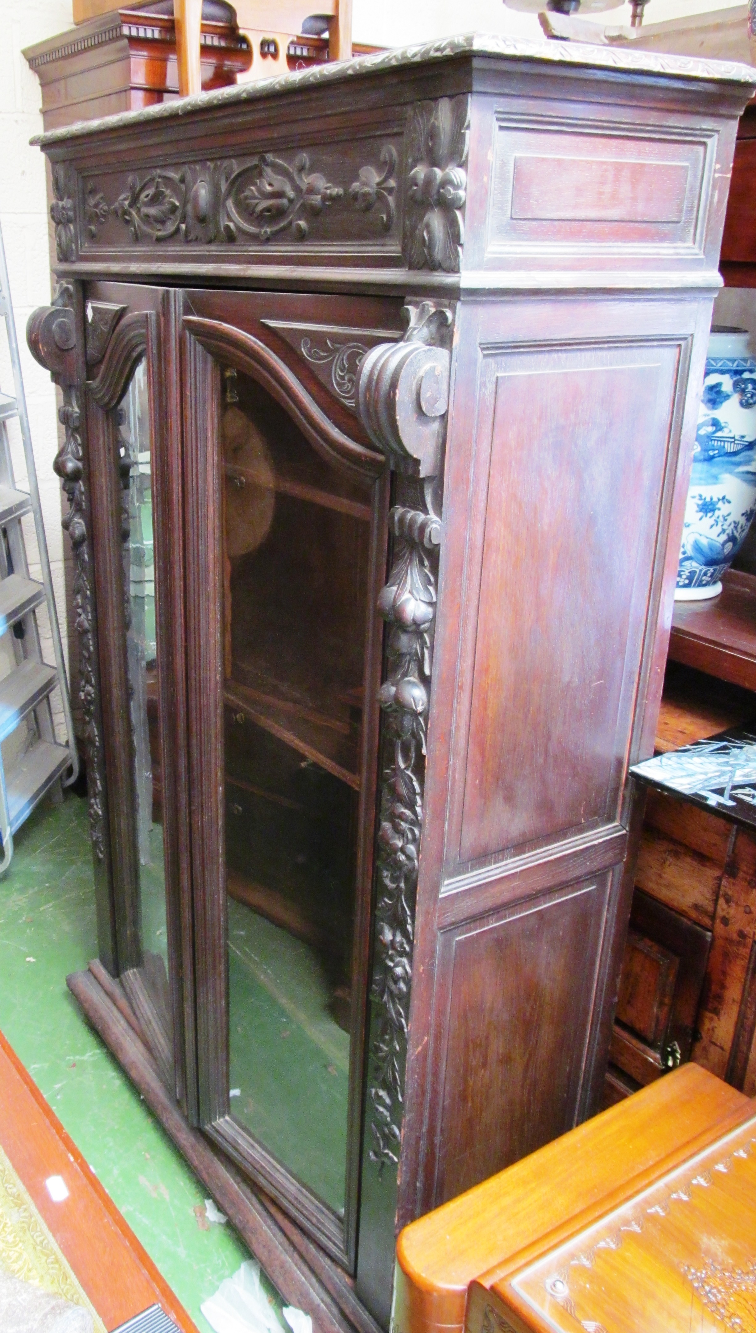 A carved oak two door display cabinet