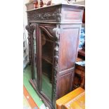 A carved oak two door display cabinet