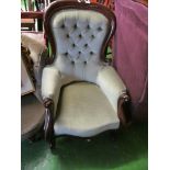 A Victorian mahogany showframe armchair with buttoned green upholstery