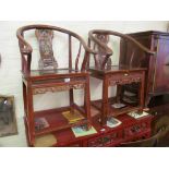 A pair of oriental shaped backed chairs with carvings of man and woman to back