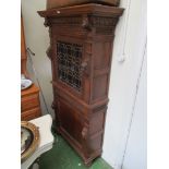 A continental oak cabinet with carved decoration, stained glass upper door and panelled door
