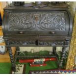 A carved oak cylinder bureau