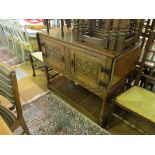 An oak small sideboard with dropleaf sides, carved cupboards and undertier.