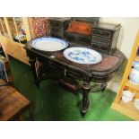 An ebonised desk with leather top rising centre revealing ink etc and drawers to each side