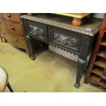 A carved oak two door sideboard deficient of back