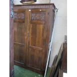 An oak wardrobe with two carved double doors and matching dressing table.