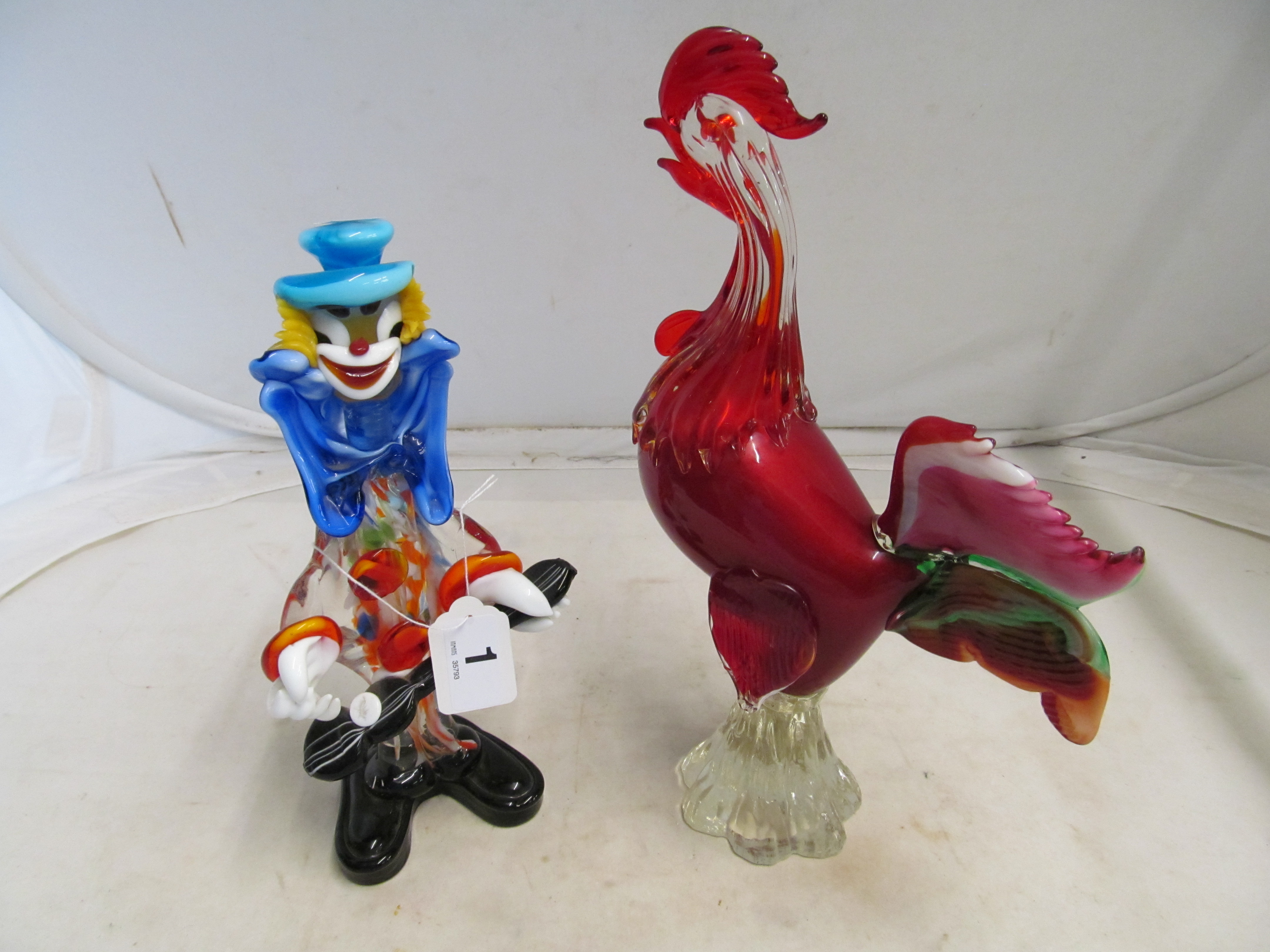 A red glass cockrell and a glass clown