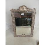 A large silver embossed dressing table mirror with cartouches of 18th Century Watteau style figures