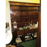 An 18th Century oak dresser three tier plate rack above three drawers and pot board