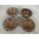 A set of four plated and treen wine coasters