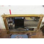 A gilt overmantel mirror with column supports.