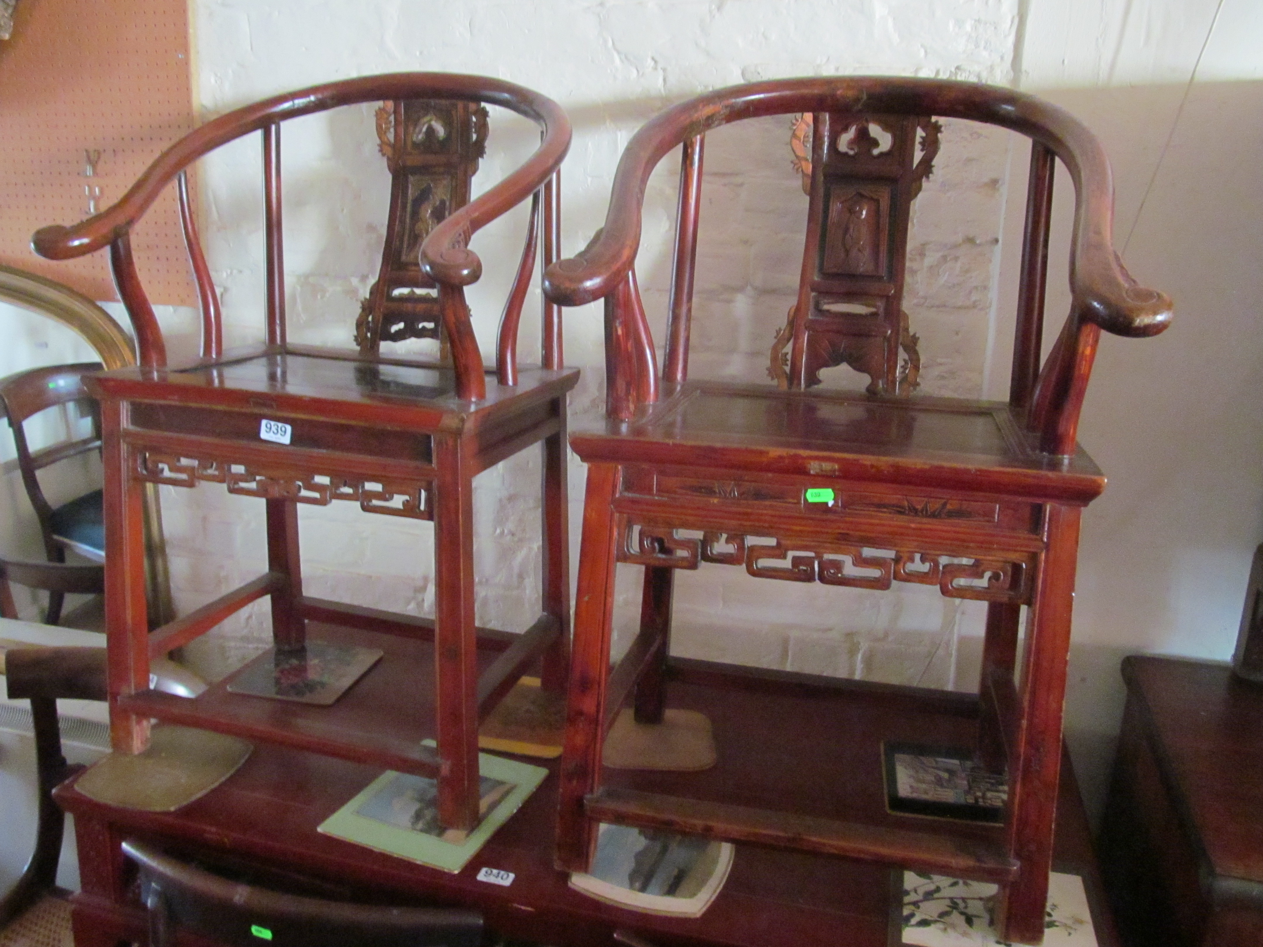 A pair of oriental shaped backed chairs with carvings of man and woman to back