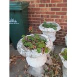 A pair of white painted garden urns with scrolling decoration