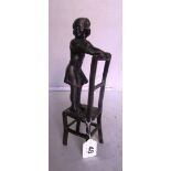 A bronze effect figure girl standing on chair.