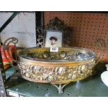 An oval brass two handled dish embossed roses with glass liner and a brass photograph frame