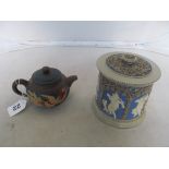 A Victorian stoneware tobacco jar applied relief figures, and a stoneware teapot with relief of a