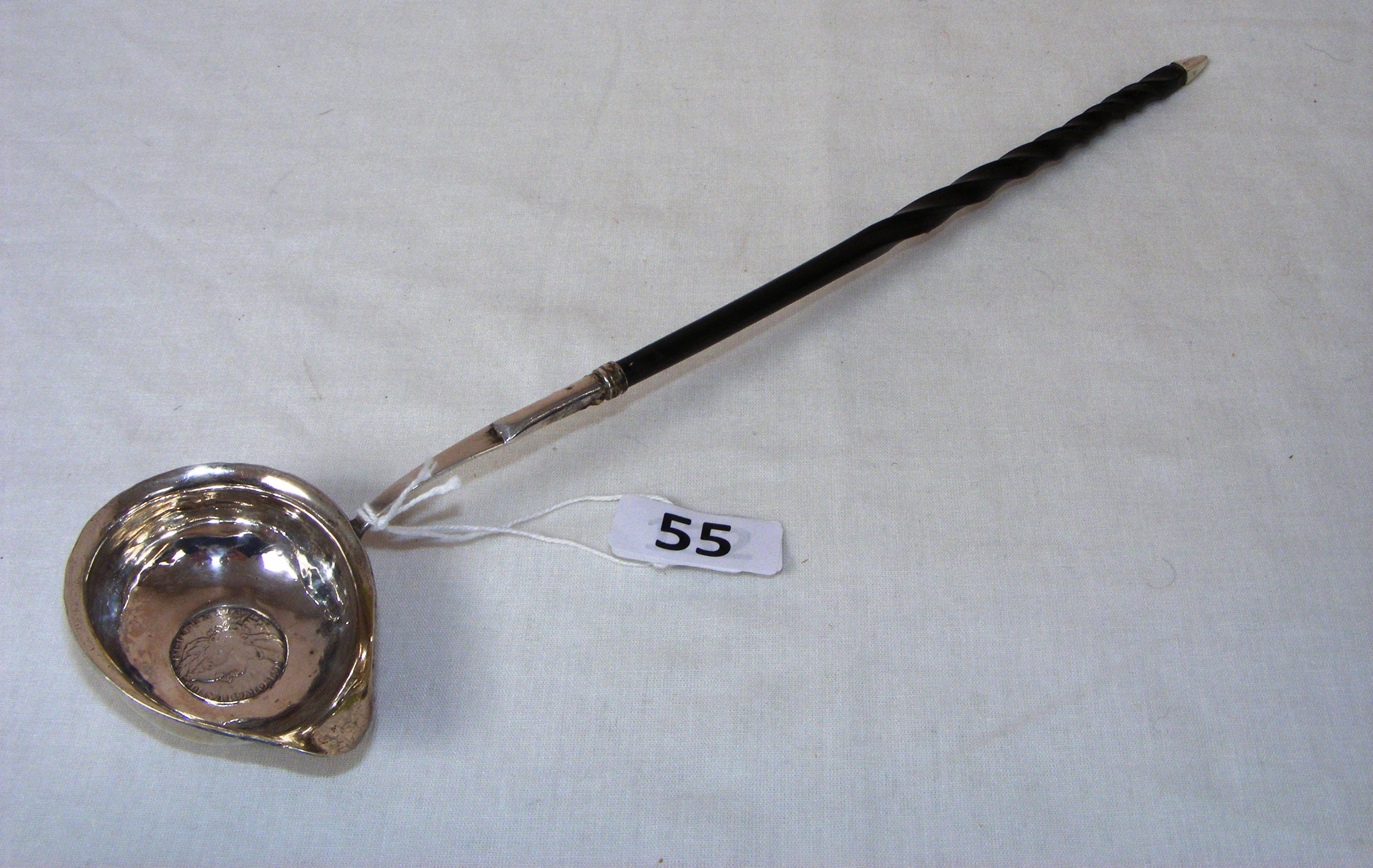 A mid 18th century George II silver punch ladle coin inset to the bowl with a wrythen bone handle,