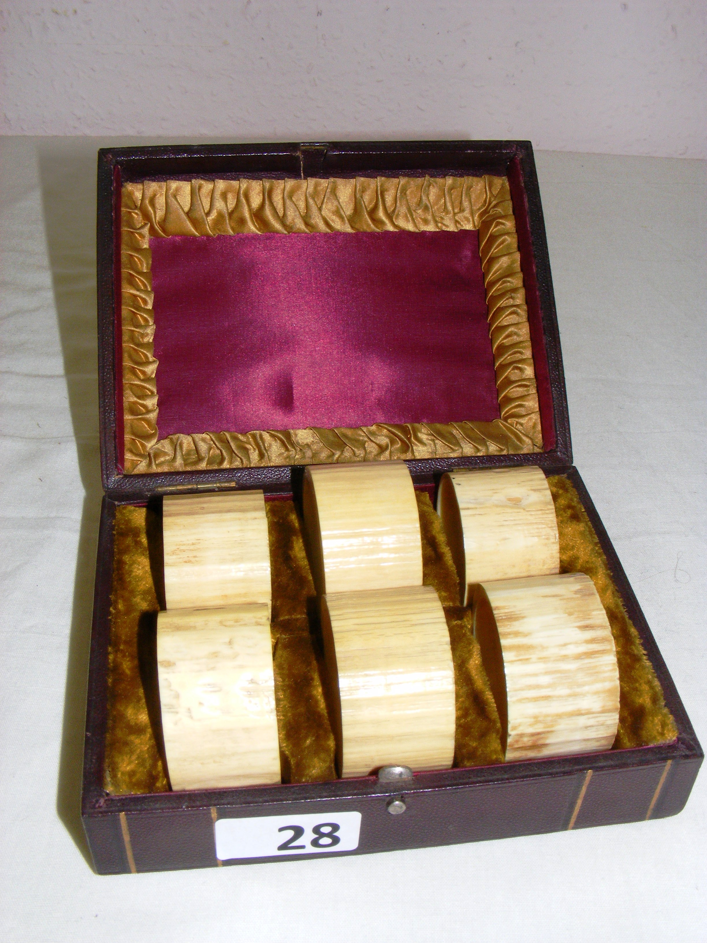 A set of Victorian carved bone napkin rings, in a tooled leather and velvet fitted case,