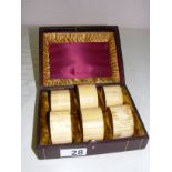 A set of Victorian carved bone napkin rings, in a tooled leather and velvet fitted case,