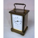 A Matthew Norman London brass carriage clock with bevelled glass panels and swing handle,