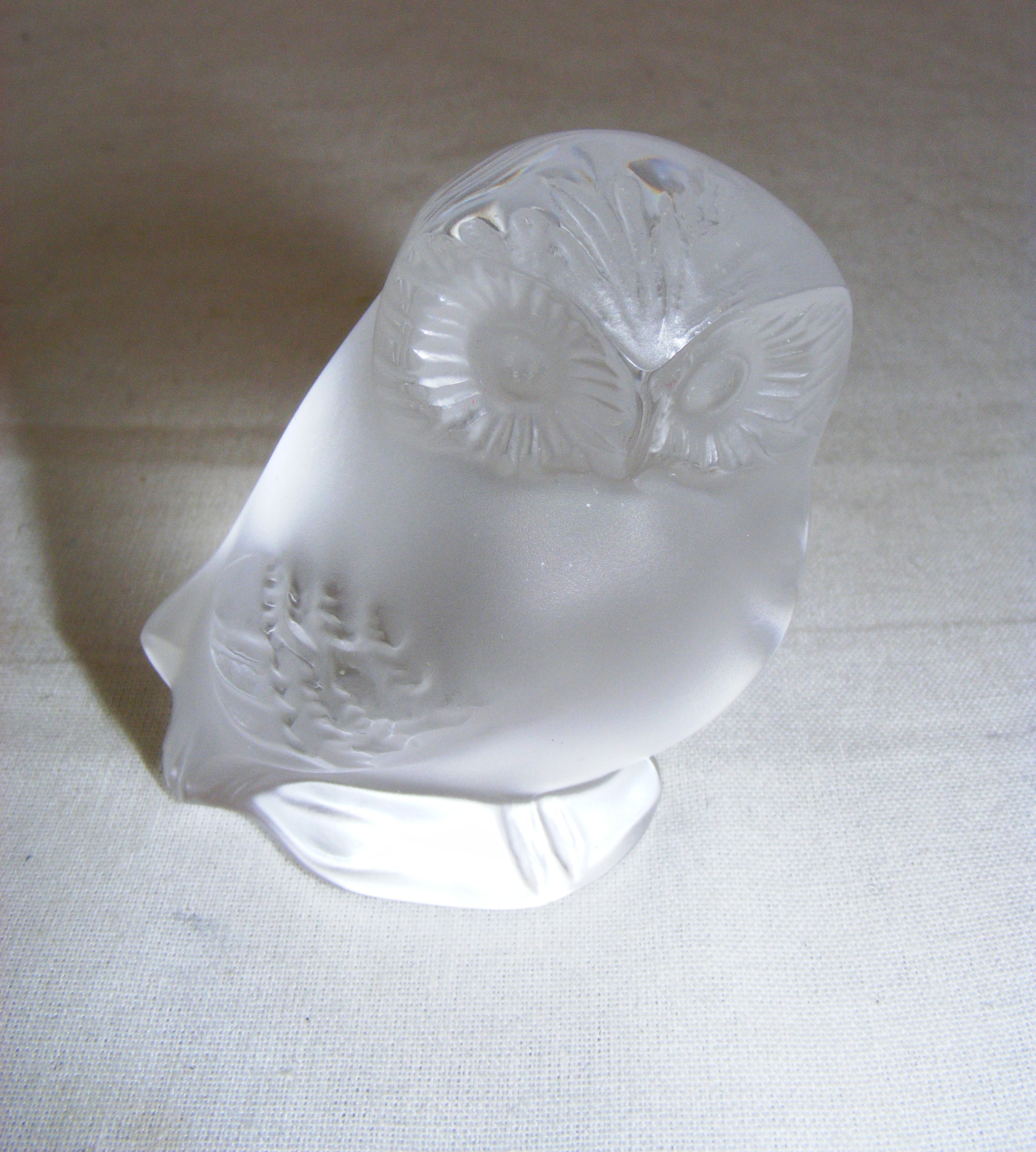 A Lalique frosted glass figurine of an owl, measuring 6cm tall, signed to the base.