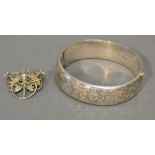 A Birmingham Silver Bangle with engraved decoration together with a white metal brooch with pierced