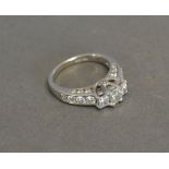 A 14ct. White Gold Three Stone Diamond Ring with diamond shoulders, approximately 1.