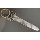 An Edwardian Silver Paper Knife/Magnifying Glass of Pierced Scroll Form, London 1900, retailed by A.
