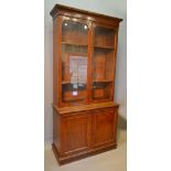 A Victorian Mahogany Bookcase, the moulded cornice above two glazed doors enclosing shelves,