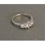 An 18ct. White Gold Three Stone Diamond Ring with a central large stone flanked by two smaller