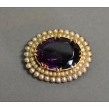 A Victorian Gold Oval Brooch set with a large Amethyst surrounded by pearls, 3.4 x 2.