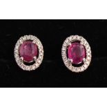 A Pair of 18ct. White Gold Ruby and Diamond Cluster Ear Studs, rubies approximately 0.95 ct,