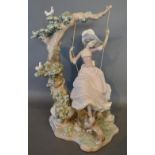 A Large Lladro Porcelain Group in the form of a Girl upon a Swing with Dog at Feet, 39 cms tall