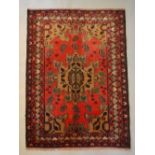 A North West Persian Woollen Rug with a Central Medallion upon a red and cream ground within