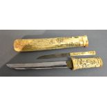 A Japanese Meiji Period Tanto with bone handle and scabbard decorated in relief with figures and