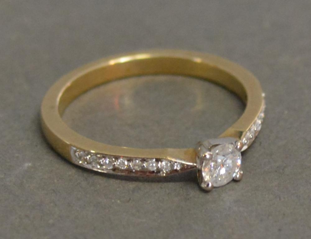 A 9ct. Yellow Gold Solitaire Ring with Diamond Shoulders, approximately 0.36 ct