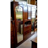 An Edwardian Mahogany Wardrobe with an arrangement of alcoves and drawers flanked by mirror doors