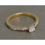 A 9ct. Yellow Gold Solitaire Ring with Diamond Shoulders, approximately 0.36 ct