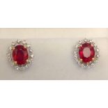A Pair of 18ct. White Gold Treated Ruby and Diamond Cluster Earrings, rubies approximately 4.65