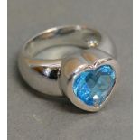 An 18ct. White Gold Ring in the form of a Heart set Pale Blue Stone