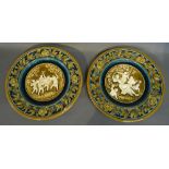 A Pair of Austrian Chargers decorated in relief with figures amongst foliage 31cms diameter