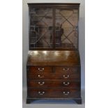 A George III Mahogany Bureau Bookcase, the moulded cornice above two astragal glazed doors enclosing