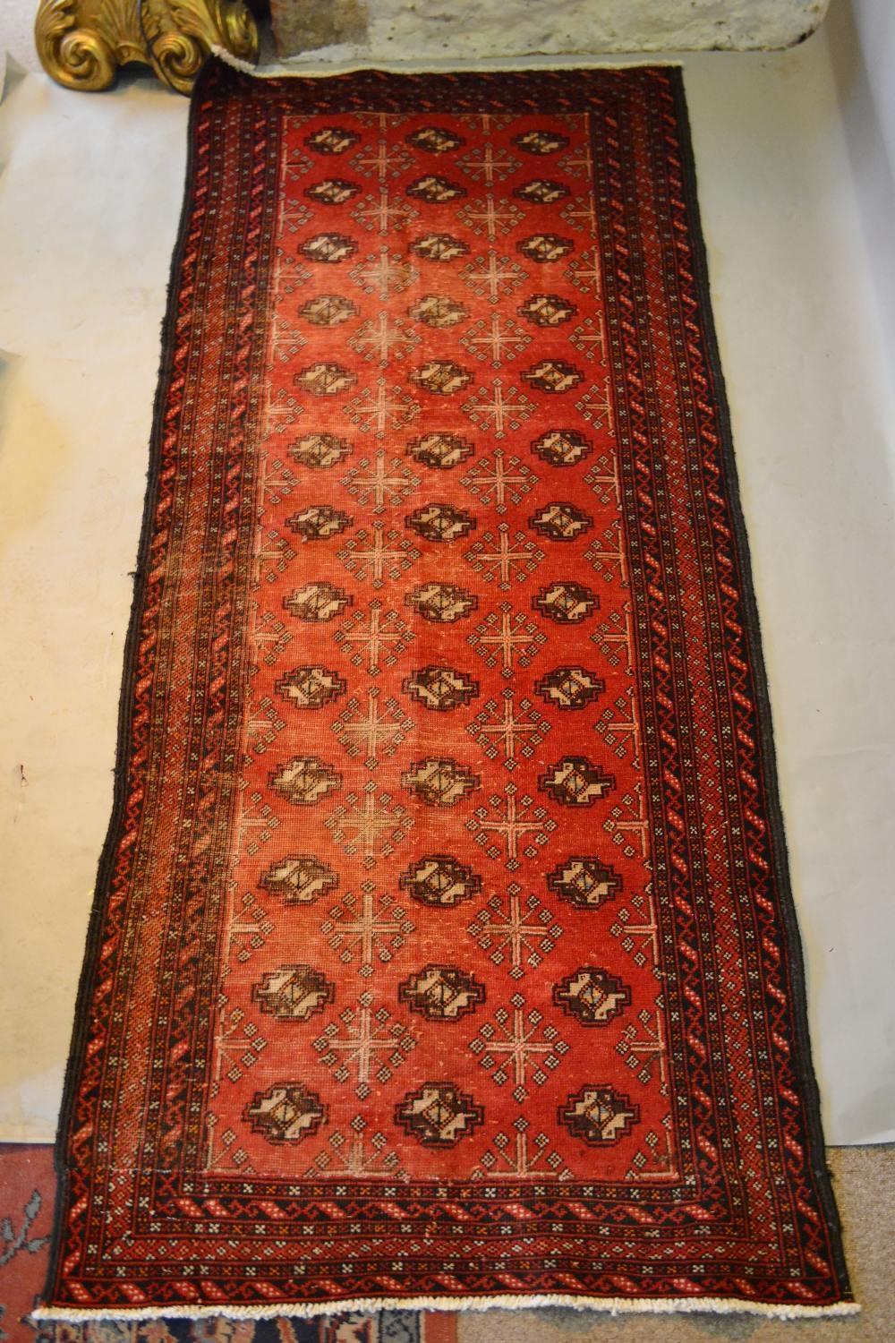 A North West Persian Woollen Runner with three rows of guls within multiple borders upon a red