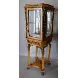 A French Gilt Metal Mounted and Marble Bijouterie, the top with a glazed door and four glazed panels