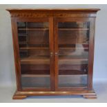 A Mahogany Bookcase, the moulded top above two glazed doors enclosing shelves, raised upon bracket